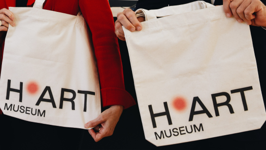 De naam H'art geshowd op tasjes tijdens de presentatie nieuwe naam en logo.