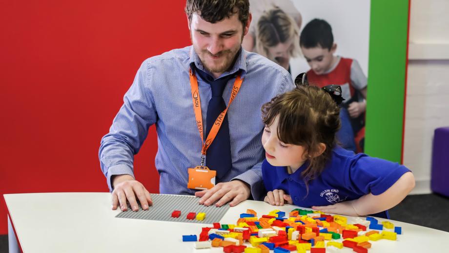 Volwassene en kind spelen met Braille Bricks