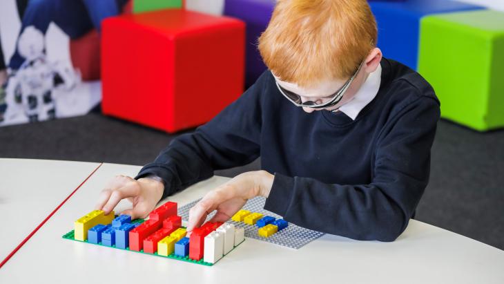 Een kind speelt met de Braille Bricks