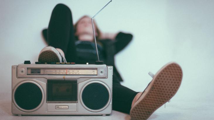 Vrouw luistert op bed naar radio