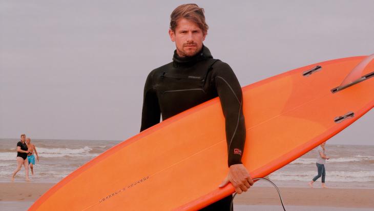 Steven Tol met surfboard in zijn handen