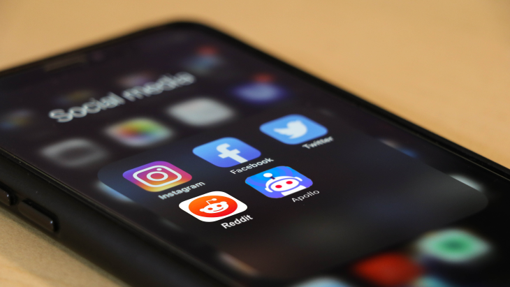 Een iPhone homescreen met social media apps, waaronder Reddit en Apollo