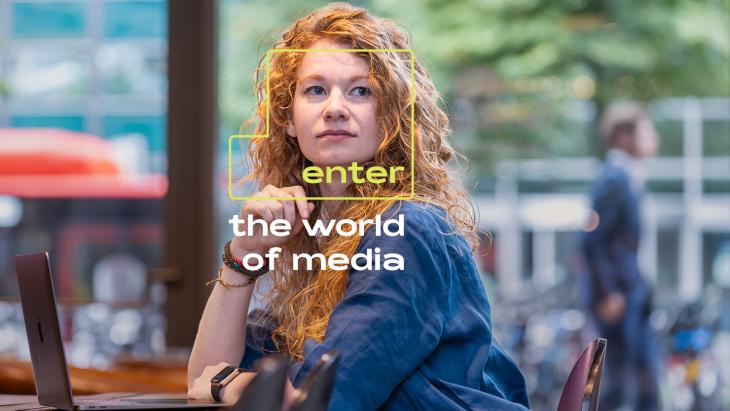 Afbeelding van jonge vrouw achter een laptop. Op de afbeelding staat: Enter the world of media.
